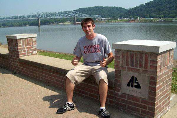 a man sitting on a brick wall