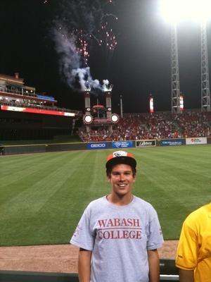 a man standing on a field with fireworks in the background