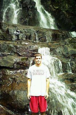 a man standing in front of a waterfall