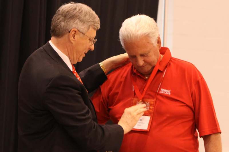 a man putting on a badge on a man's shirt