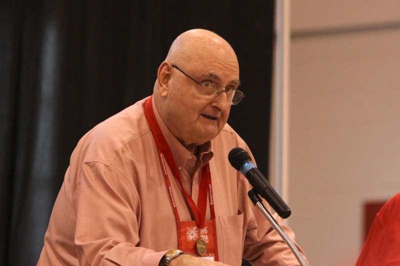 a man in glasses speaking into a microphone