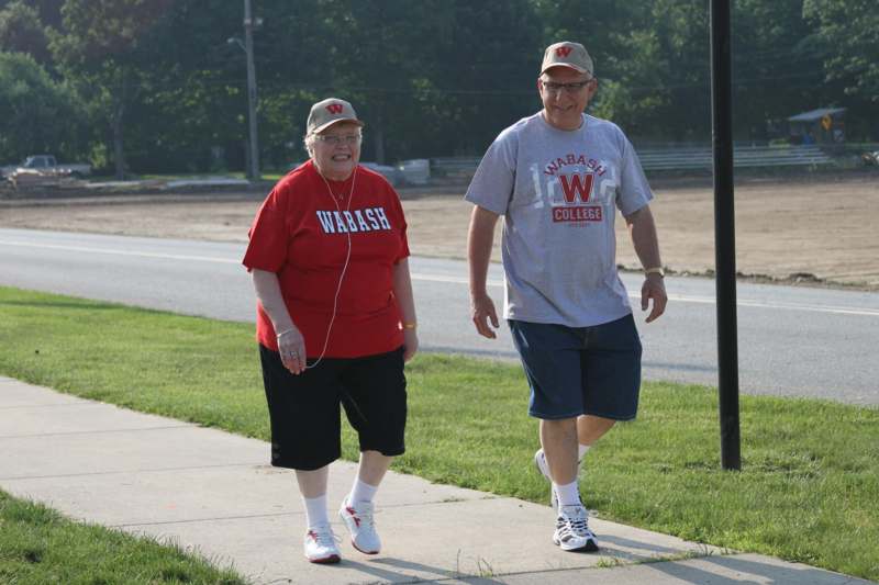 a man and woman walking on a sidewalk