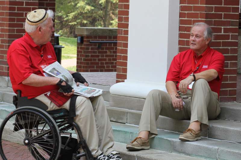 a man in a wheelchair talking to another man
