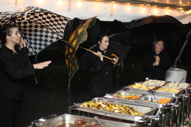 a group of people standing under a tent with food