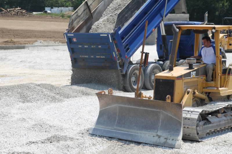 a construction vehicle loading gravel into a truck
