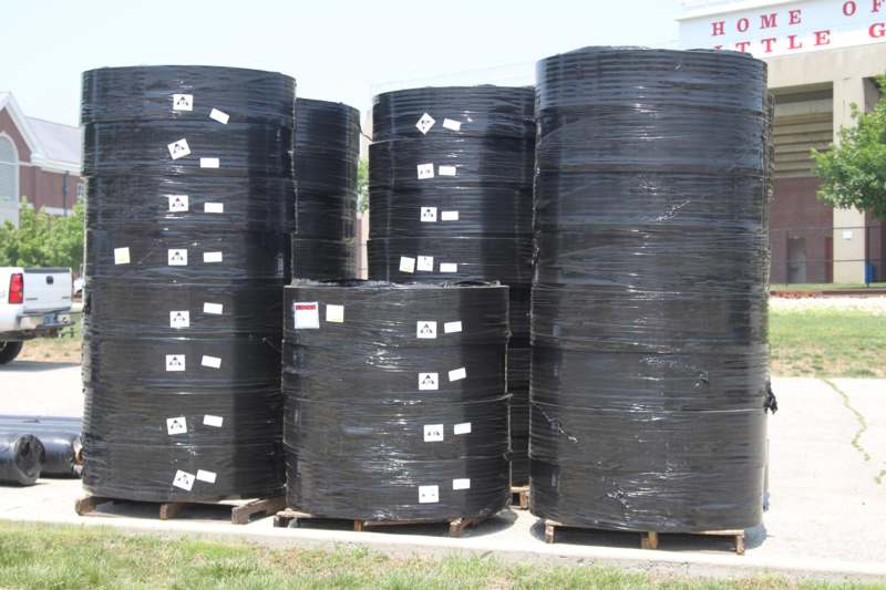 several large black plastic drums