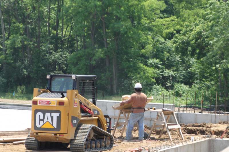 a man standing next to a bulldozer