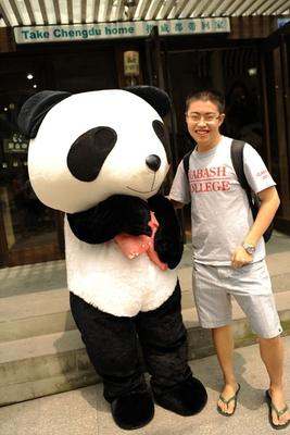 a man standing next to a person in a panda garment