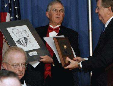 a man holding a plaque and a man holding a picture