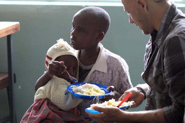 a man feeding a child with food
