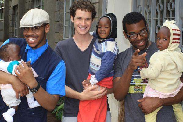 a group of men holding a baby
