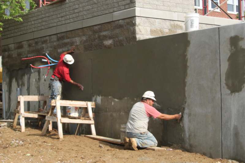 a group of men painting a wall