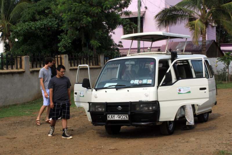 a group of men standing next to a white van