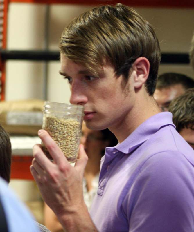 a man holding a glass of grain