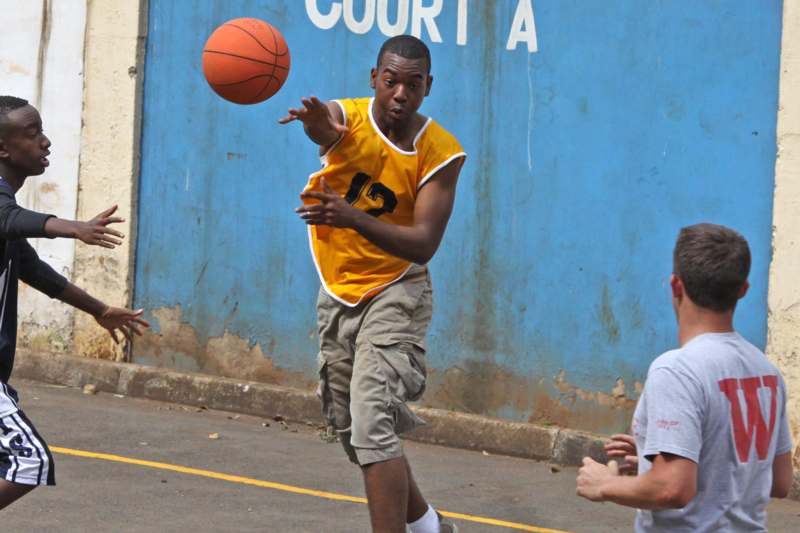 a man in a yellow shirt and shorts playing basketball