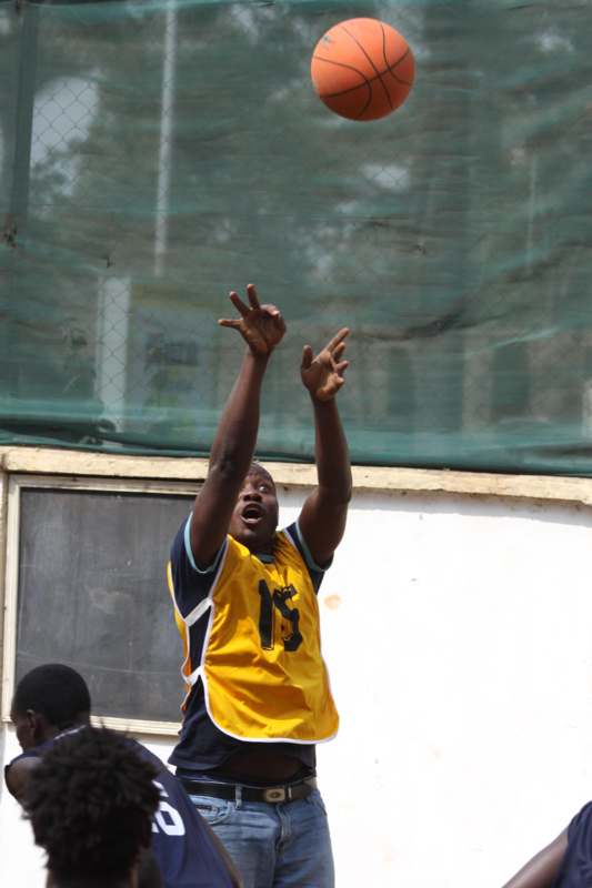 a man in a yellow jersey reaching for a ball