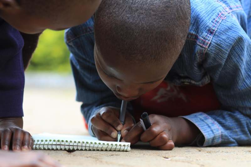 a boy writing on a notebook