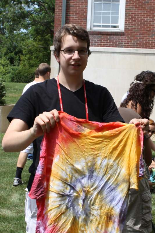 a man holding a tie dye shirt
