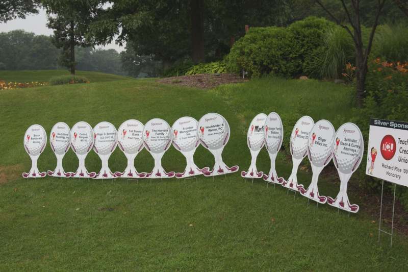 a group of golf signs on a lawn