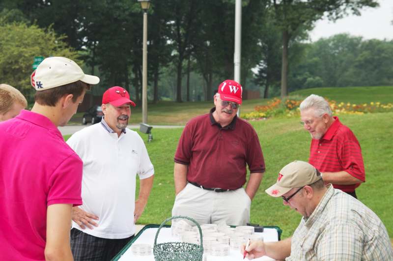 a group of men in red hats standing around a table