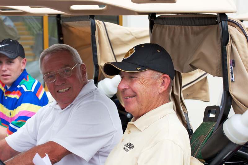 a couple of men sitting in a golf cart