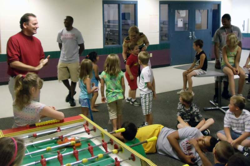 a group of kids playing foosball
