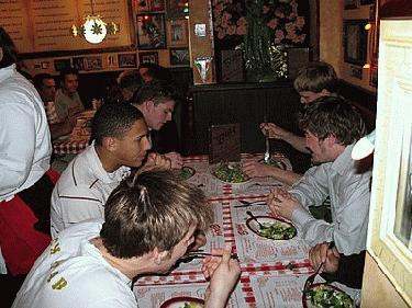 a group of young men eating at a restaurant