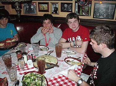 a group of people sitting at a table eating