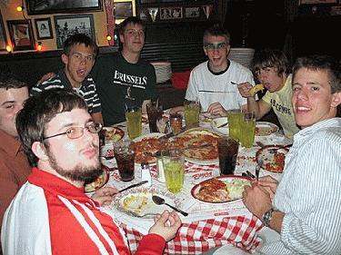 a group of people eating pizza
