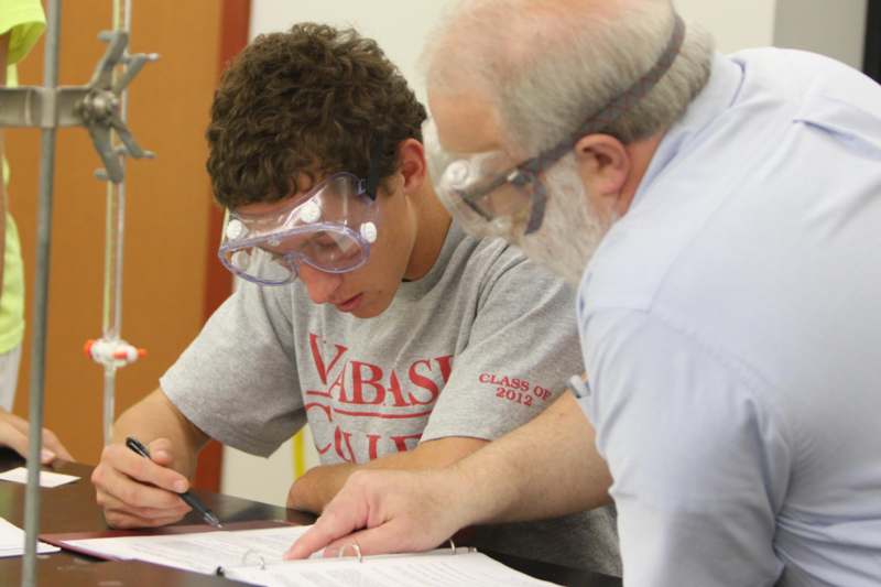 a man wearing goggles and writing on a paper