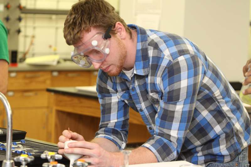 a man wearing goggles and safety goggles working on a laptop