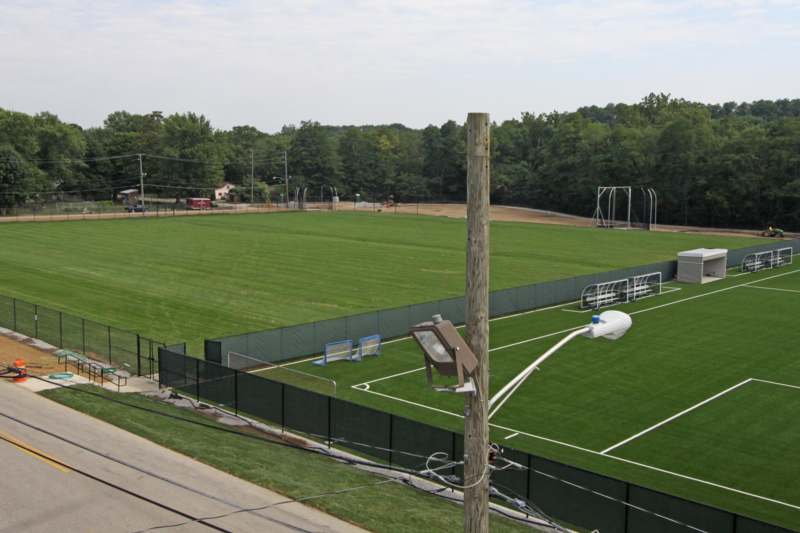 a football field with a fence and a lamp post