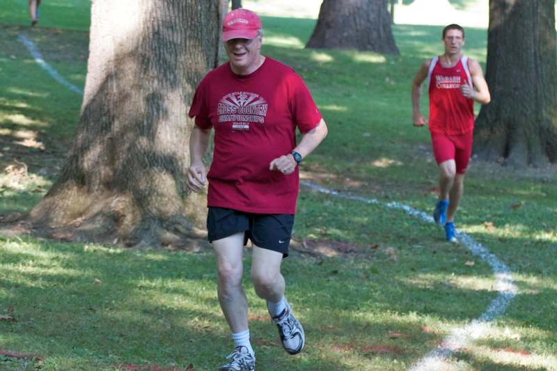 a man in red shirt running on grass