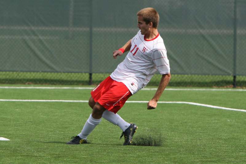 a man in a football uniform kicking a ball