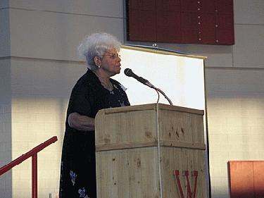 an old woman speaking into a microphone