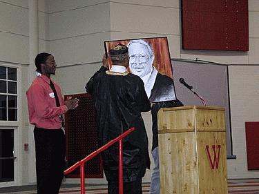 a man standing at a podium with a man in a robe
