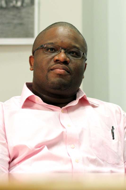 a man wearing glasses and a pink shirt