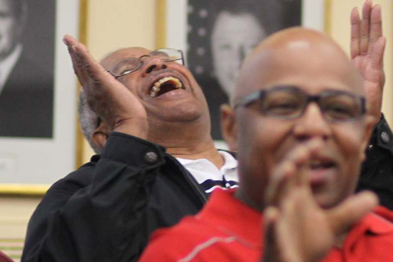 a man laughing with his hands up