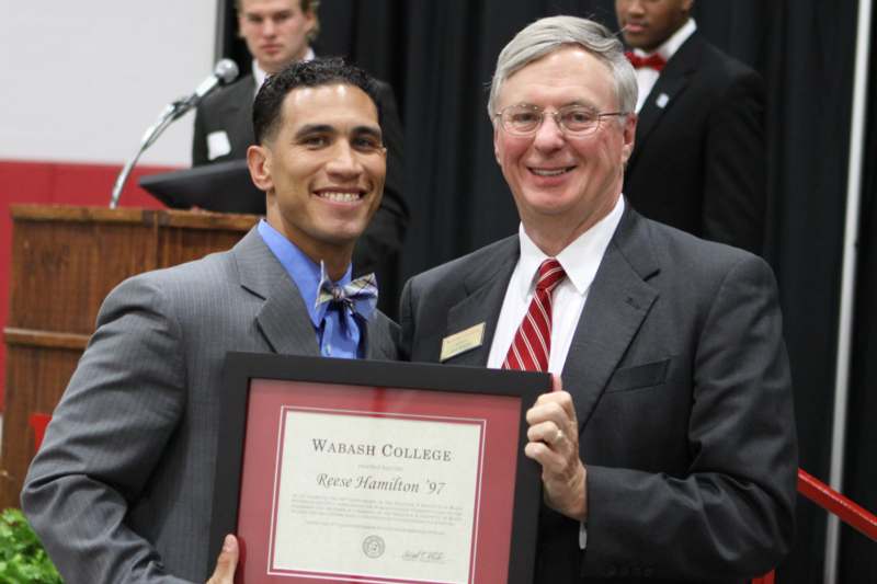 a man holding a plaque with a man in a suit
