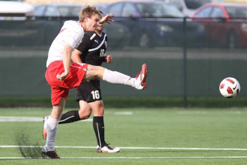 a man kicking another man on a field