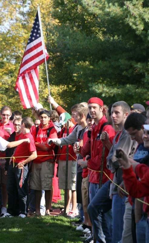 a group of people in red shirts holding a flag
