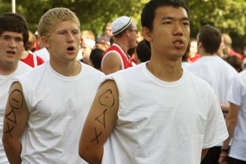 two men in white shirts with writing on their arm