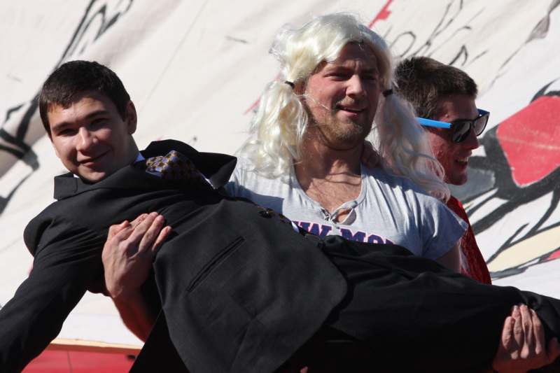 a man in a wig carrying another man