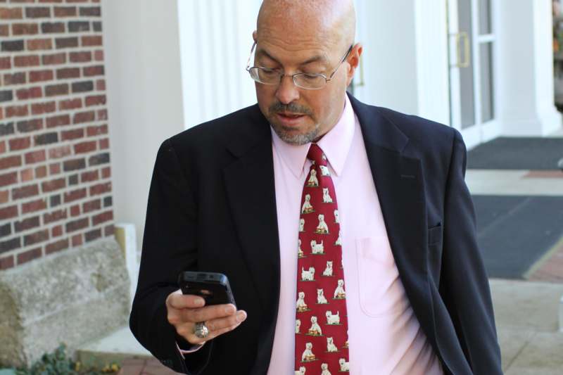 a man in a suit and tie looking at a cell phone