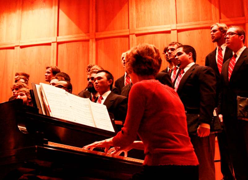 a group of people in suits and a piano