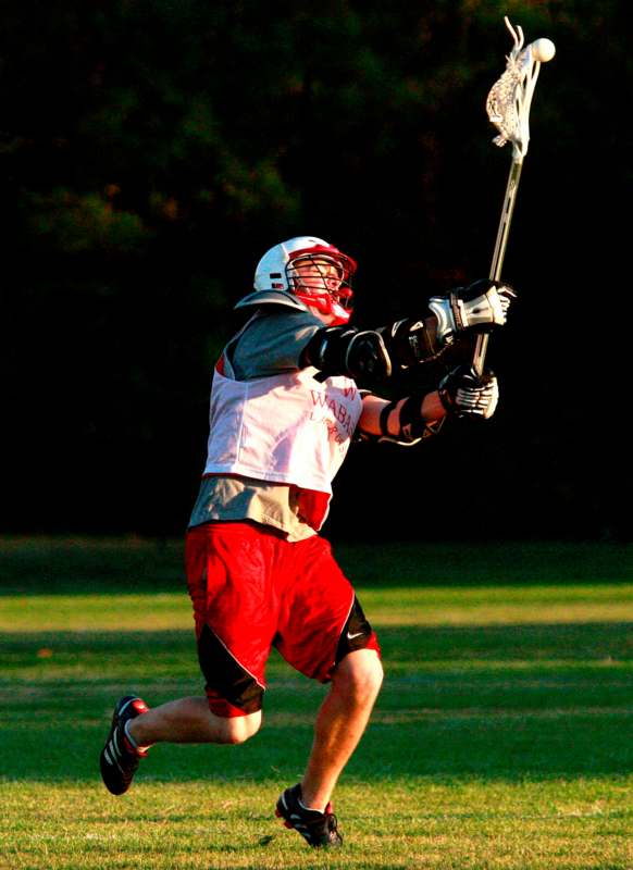 a man in a helmet holding a lacrosse stick