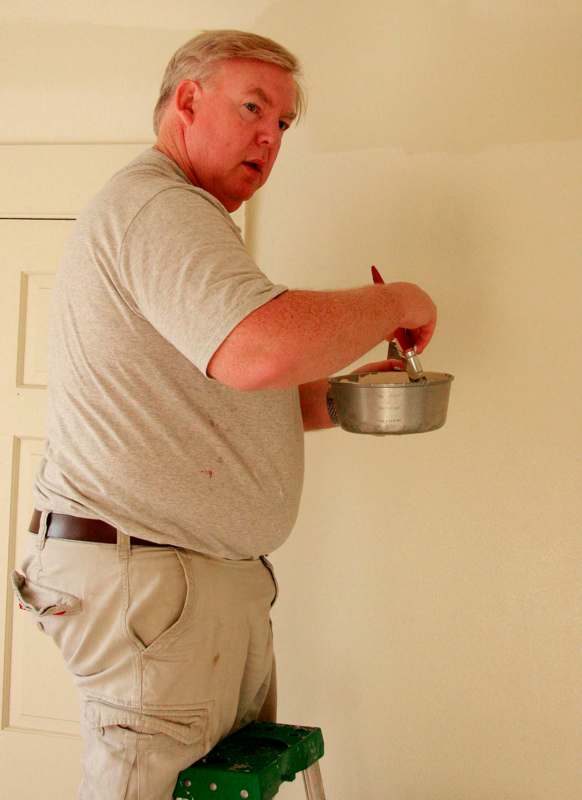 a man holding a bowl and spatula