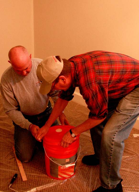 a couple of men looking at a bucket
