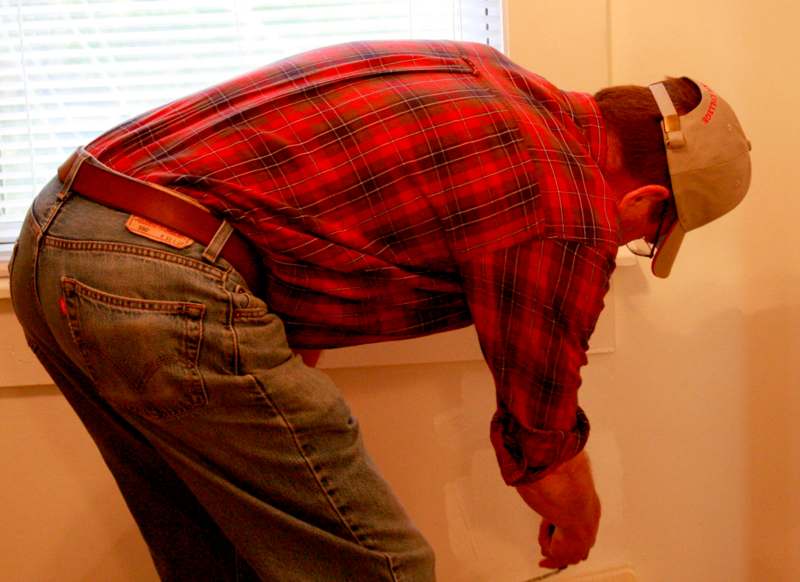 a man wearing a red plaid shirt and blue jeans