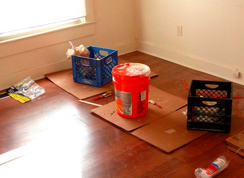 a bucket of paint on a cardboard floor